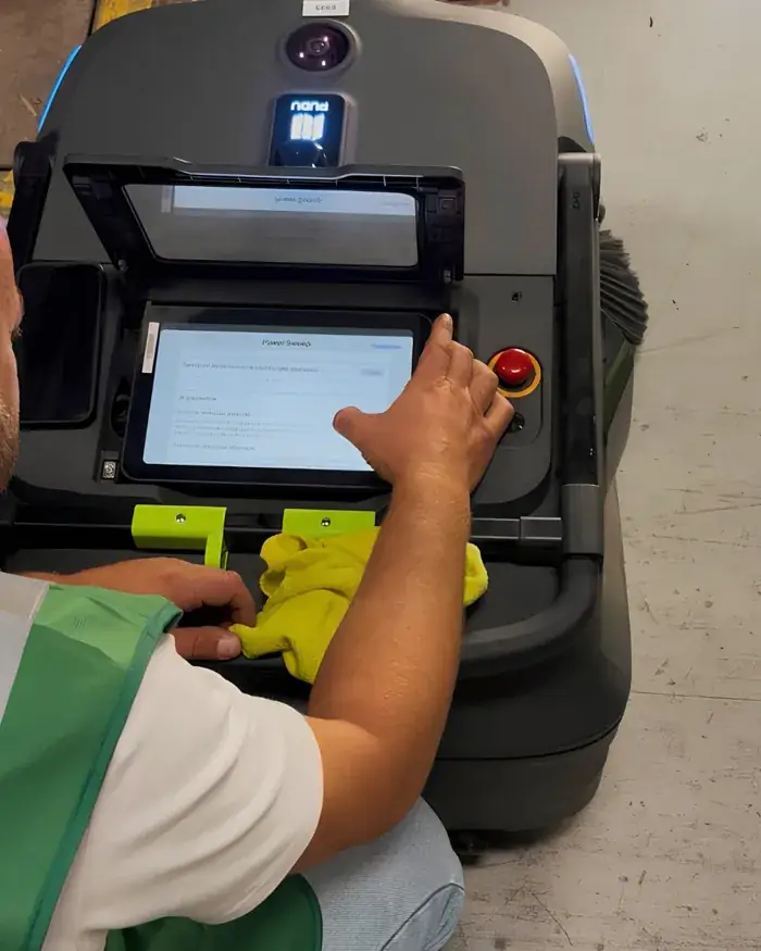 Un technicien Elio Robot configurant l'écran de bord d'un robot autonome