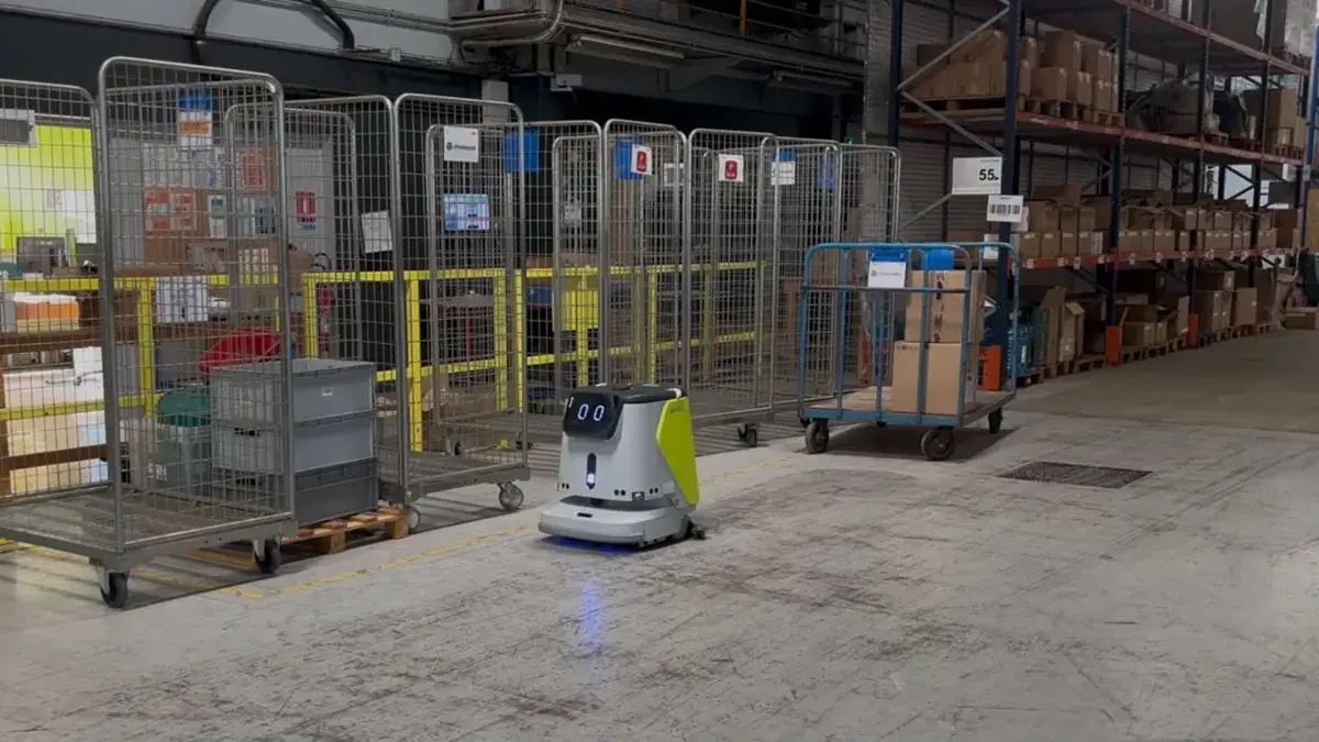 Robot de nettoyage autonome circulant dans une allée d'entrepôt